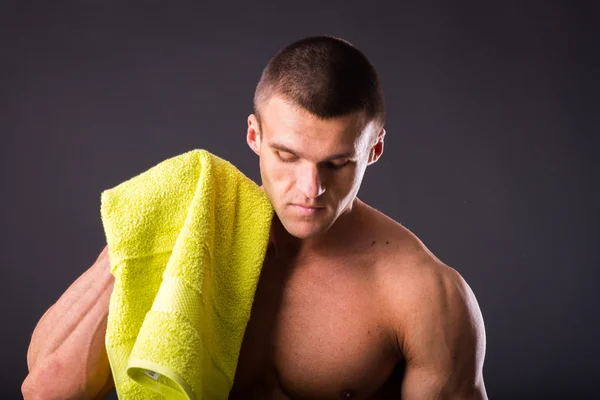 Fitness man holding a yellow towel — Stock Photo, Image