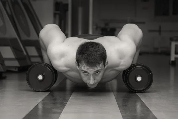 Мужчина делает силовые упражнения с гантелями — стоковое фото
