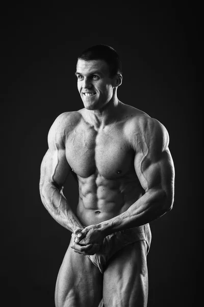 Muskelkräftiger Bodybuilder zeigt seine Muskeln. — Stockfoto