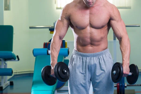 Homem musculoso trabalhando com halteres — Fotografia de Stock