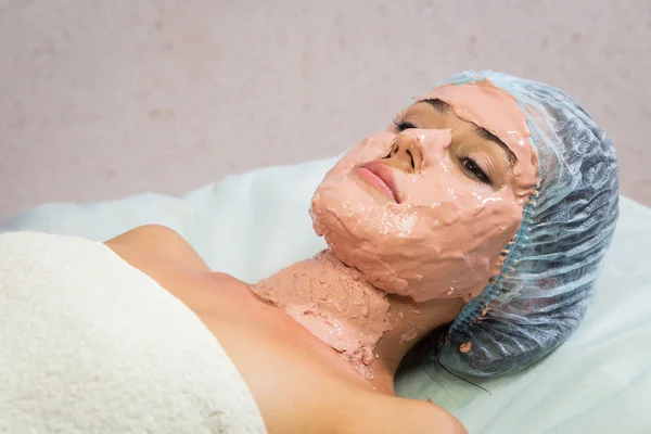 Jonge vrouw ontvangende gezichtsmasker — Stockfoto