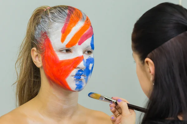 Нанесення креативного макіяжу на обличчя дівчини — стокове фото