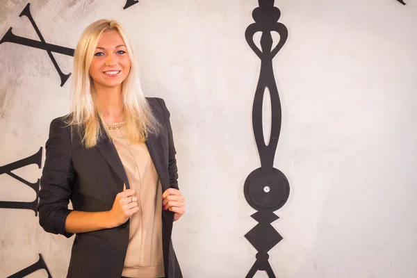 Woman standing near wall clock — Stock Photo, Image