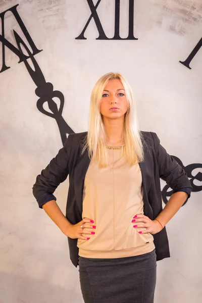 Woman standing near wall clock — Stock Photo, Image