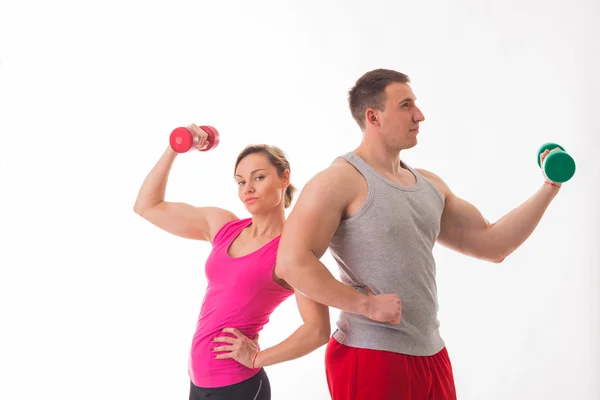 Athletic couple holding dumbbells — Stock Photo, Image