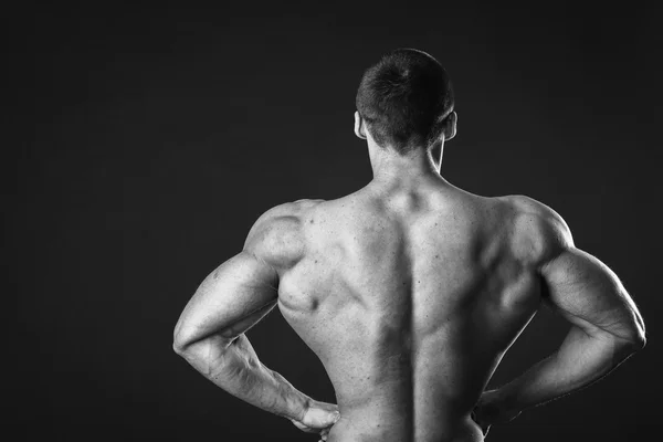 Gespierde bodybuilder toont zijn spieren. — Stockfoto