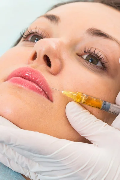 Kosmetikerin spritzt der Patientin Injektion ins Gesicht — Stockfoto