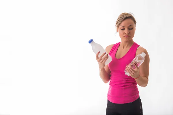 Girl holding bottle of water and milk — Stock Photo, Image