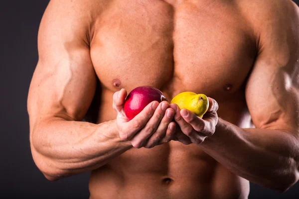 健美运动员抱着新鲜的水果 — 图库照片