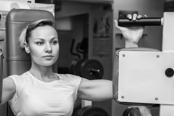 Blonde trained on the simulator in the gym — Stock Photo, Image