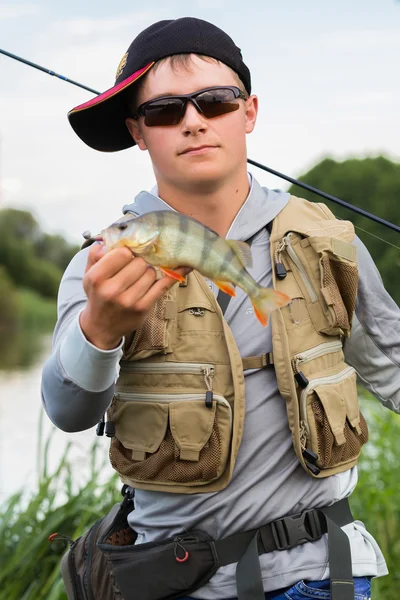 Fisherman holding a perch in hand — Stock Photo, Image