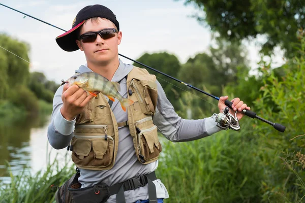 Fisherman holding a perch in hand — Stock Photo, Image