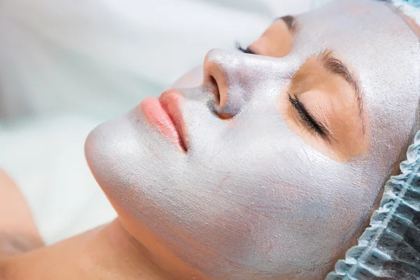 Mujer joven recibiendo máscara facial —  Fotos de Stock