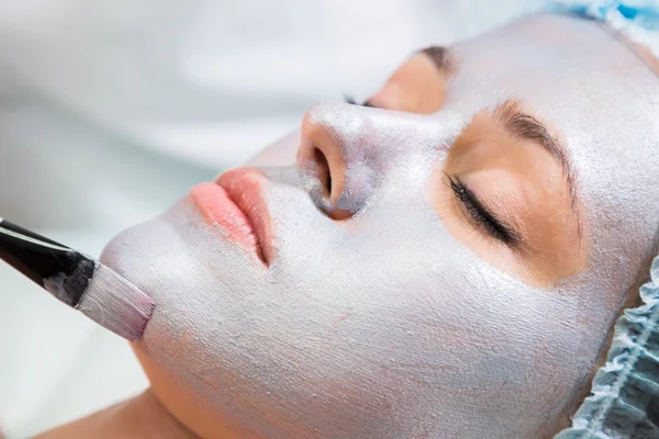 Jovem mulher recebendo máscara facial — Fotografia de Stock