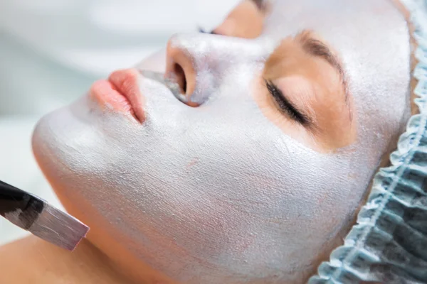 Young woman receiving facial mask — Stock Photo, Image