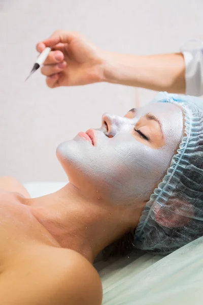 Young woman receiving facial mask — Stock Photo, Image