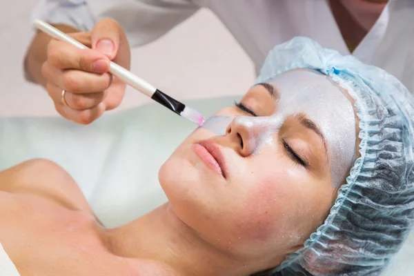 Young woman receiving facial mask — Stock Photo, Image