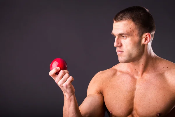 М'язовий чоловік тримає стигле яблуко — стокове фото
