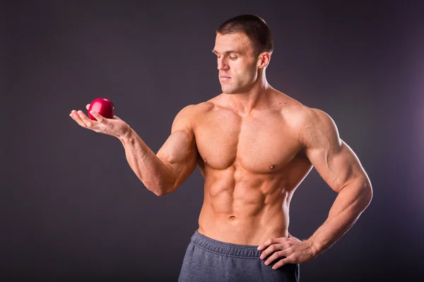 М'язовий чоловік тримає стигле яблуко — стокове фото