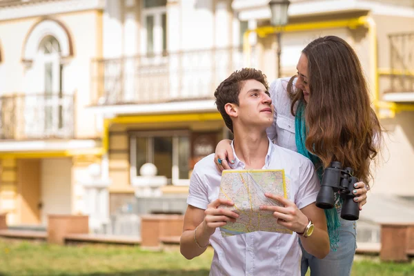 Koppel met kaart en een verrekijker op straat — Stockfoto