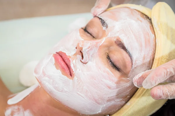 Jovem mulher recebendo máscara facial — Fotografia de Stock