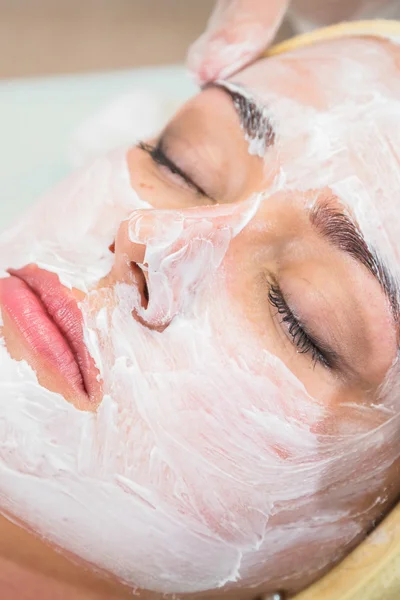 Young woman receiving facial mask — Stock Photo, Image