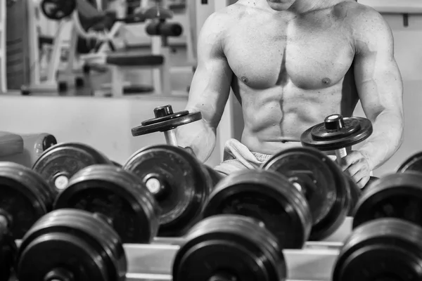 Homem musculoso trabalhando com halteres — Fotografia de Stock