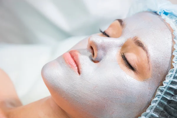 Young woman receiving facial mask — Stock Photo, Image