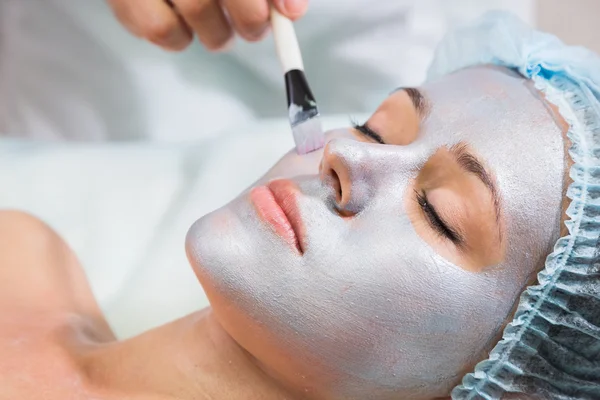 Young woman receiving facial mask — Stock Photo, Image