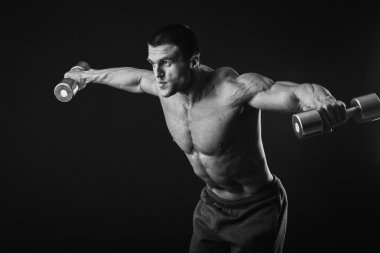 adam dumbbells ile çalışmaları yapan