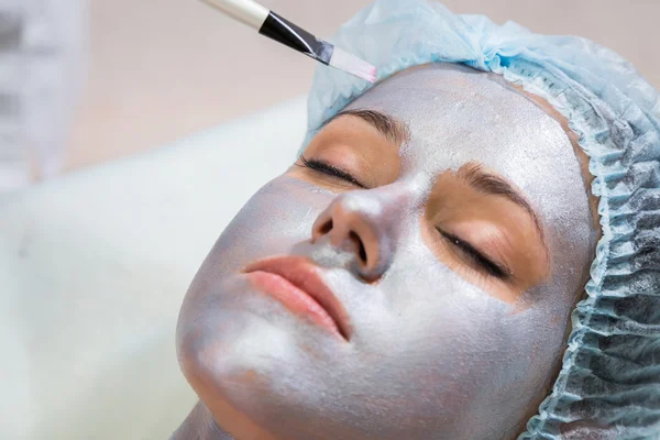 Mujer joven recibiendo máscara facial —  Fotos de Stock