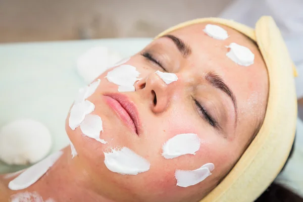 Jovem mulher recebendo máscara facial — Fotografia de Stock