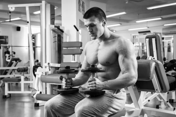 Homem musculoso trabalhando com halteres — Fotografia de Stock