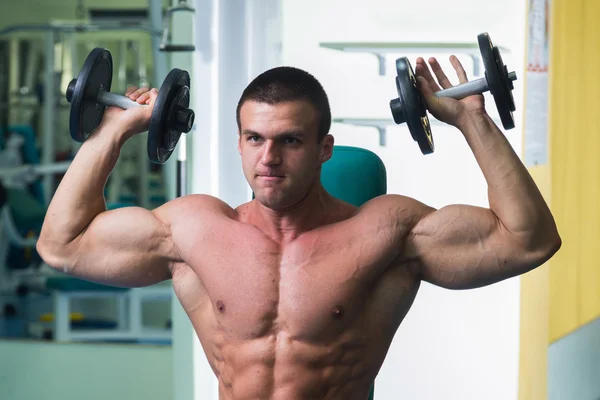 Muscular man working out with dumbbells — Stock Photo, Image