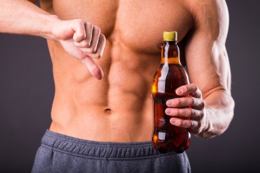 Elinde bir bira ile kas adam