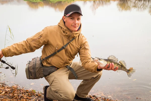 Um jovem com um peixe — Fotografia de Stock