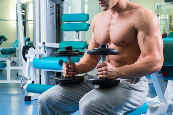 Homme faisant des exercices avec haltères dans la salle de gym — Photo