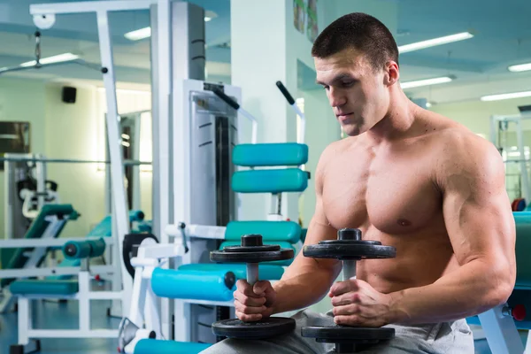 Uomo che fa esercizi con manubri in palestra — Foto Stock