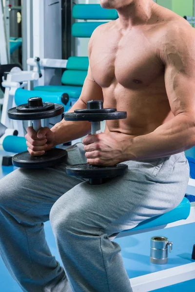 Uomo che fa esercizi con manubri in palestra — Foto Stock