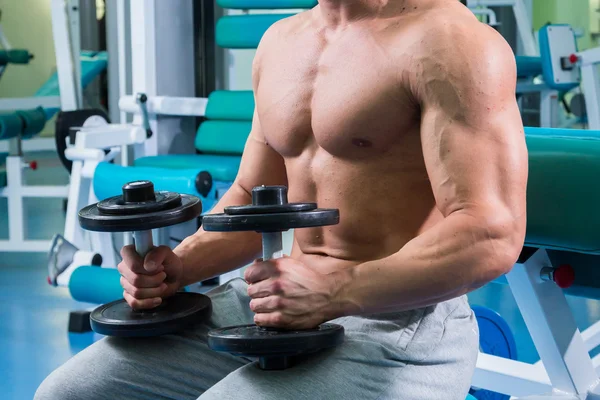 Homme faisant des exercices avec haltères dans la salle de gym — Photo