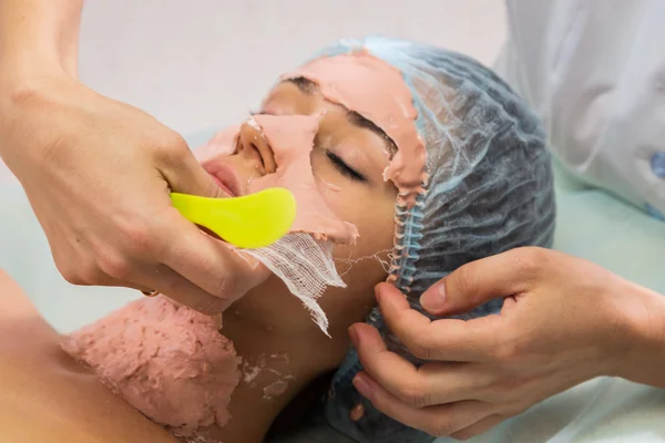 Mujer joven recibiendo máscara facial — Foto de Stock