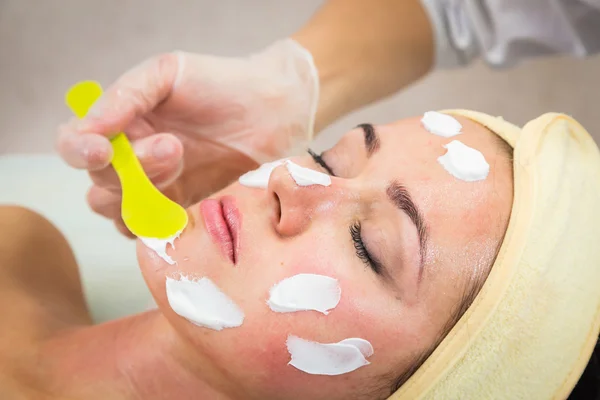 Young woman receiving facial mask — Stock Photo, Image