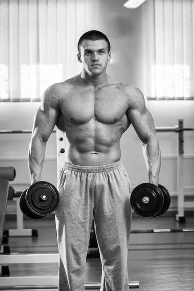 Hombre haciendo ejercicios con pesas en el gimnasio — Foto de Stock