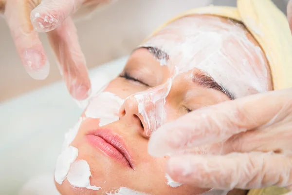 Mujer joven recibiendo máscara facial — Foto de Stock