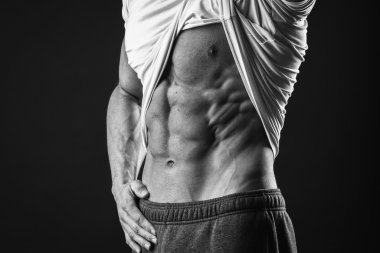 Adam onun karın kasları gösterir