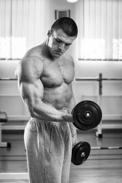 Uomo che fa esercizi con manubri in palestra — Foto Stock