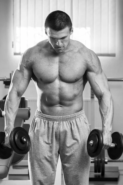 Hombre haciendo ejercicios con pesas en el gimnasio —  Fotos de Stock