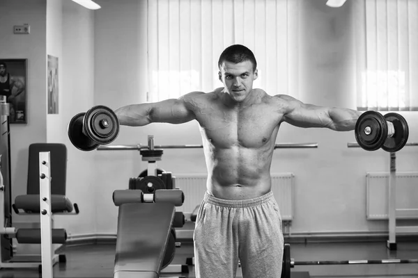 Homme faisant des exercices avec haltères dans la salle de gym — Photo