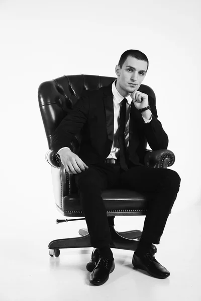 Homem de negócios sentado na cadeira de couro — Fotografia de Stock