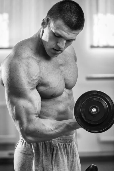 Uomo che fa esercizi con manubri in palestra — Foto Stock